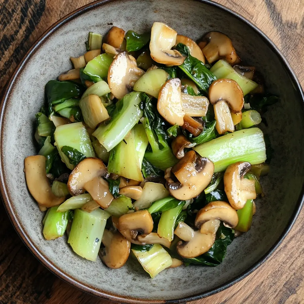 A vibrant stir fry with tender bok choy, sautéed mushrooms, and a savory garlic-ginger sauce in a skillet.